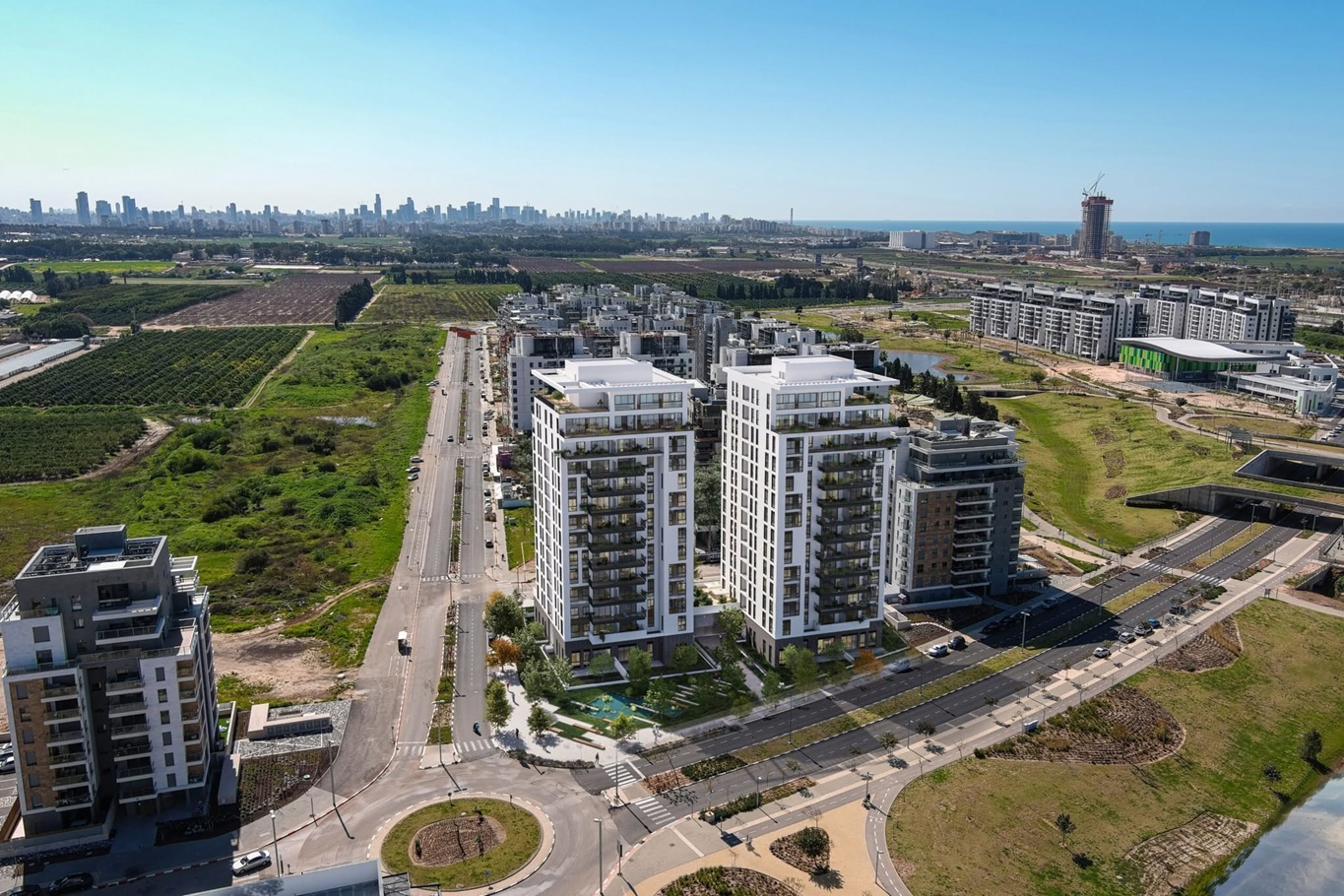 רחוב שכונתי חדש עם בנייני מגורים ועצים